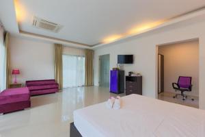 a large white room with a bed and a chair at Villa Oxavia in Rawai Beach