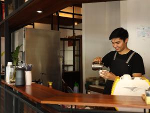 a man standing in a kitchen preparing food at Neighbor Phuthon in Bangkok