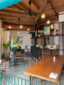 a restaurant with tables and chairs and a bar at Neighbor Phuthon in Bangkok
