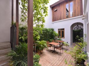 a courtyard with a wooden table and chairs at Neighbor Phuthon in Bangkok