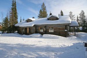 a log cabin with snow on top of it at Holidayhome Sompio in Luosto