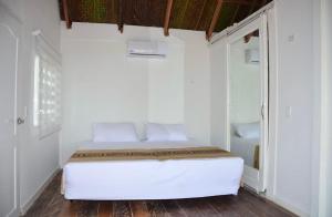 a white bedroom with a bed in a room at Marine Beach Hotel in Cartagena de Indias