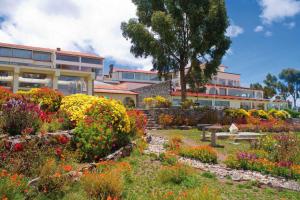 een tuin met bloemen voor een gebouw bij Taypikala Lago in Puno