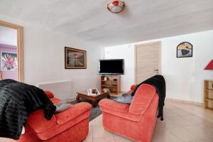 a living room with two chairs and a tv at Appartement Type F4 in Maurens