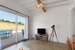 a living room with a television and a camera on a tripod at Maison Mendi Borda Pays Basque in Larribar-Sorhapuru