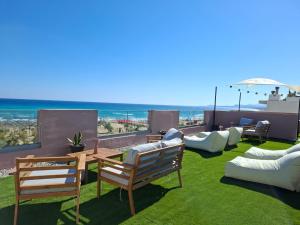 a patio with chairs and a table and an umbrella at Thalyra in Rethymno