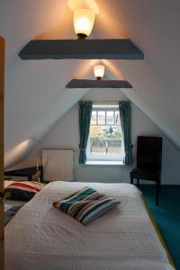 a bedroom with a bed and a window with a light at Hafenambiente in Husum