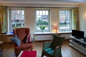 a living room with a couch and chairs and windows at Hafenambiente in Husum