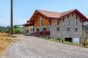 a house with a wooden roof on a dirt road at Maison Mendi Borda Pays Basque in Larribar-Sorhapuru