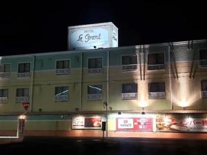 a building with a sign on top of it at night at HOTEL Le Grand in Matsuzaka