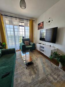 a living room with a couch and a tv at DSTAY HOMEs in Eldoret