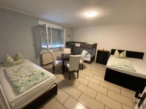 a room with two beds and a table and a chair at Bauernhof Privatzimmer Frei WiFi Gemeinschaftsbad in Hausbreitenbach