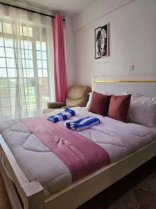 a large bed with two blue pillows on it at DSTAY HOMEs in Eldoret