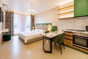 a bedroom with a bed and a table and a kitchen at Oryn Suites in Tirana