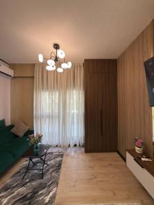 a living room with a green couch and a chandelier at Чарвак Дарвозаси in Chorwoq