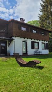 a large house with a hammock in the yard at Ferienhaus Bambach in Fladungen