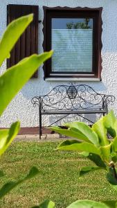 a bench sitting in the grass in front of a window at Ferienhaus Bambach in Fladungen +8 photos