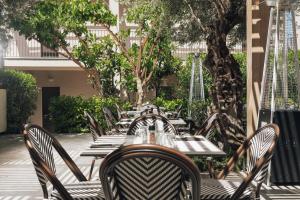 a row of tables and chairs in a courtyard at New Beach Hotel in Planos