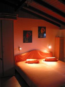 a bedroom with an orange bed with two pillows at Ferienhaus Bambach in Fladungen