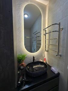 a bathroom with a sink with a large mirror at Чарвак Дарвозаси in Chorwoq