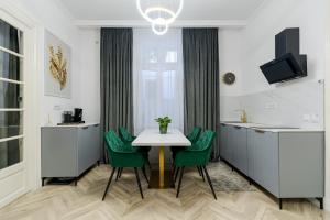 a dining room with a table and green chairs at Downtown Bucharest Villa Private Garden & Garage for Parking in Bucharest