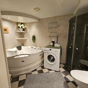 a bathroom with a tub and a washing machine at Centrala Tanumshede in Tanumshede +20 photos