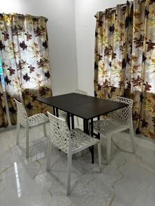 a black table with two chairs and curtains at Dreamy beach villa in Pondicherry