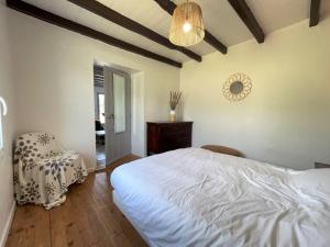 a bedroom with a bed and a chair and a clock at Elizako bidea in Mendive