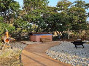 a walkway with a barbecue and a grill and trees at Breezy Hills Cottages - Moonlight Cottage in Fredericksburg +2 photos