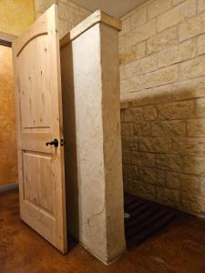 a room with a wooden door and a brick wall at Breezy Hills Cottages - Moonlight Cottage in Fredericksburg