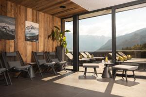 a room with chairs and tables and large windows at Alpine Resort Goies Superior in Ladis