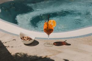 a drink sitting next to a pool with a bowl of nuts at Alpine Resort Goies Superior in Ladis