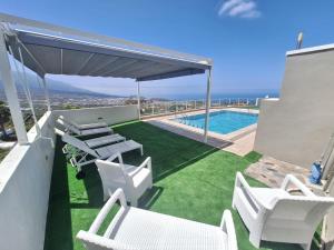 a patio with white chairs and a swimming pool at casa moni 2 in El Paso