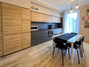a kitchen with wooden cabinets and a table and chairs at Mamma Oca in Esanatoglia