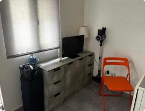 a room with a desk with a television and a red chair at Aprile in Palavas-les-Flots