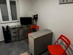 a room with a desk with a computer and a red chair at Aprile in Palavas-les-Flots