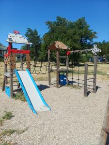 a playground with a blue slide in a park at Camping Mas Sud Ardèche in Saint-Just