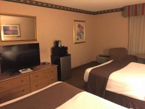 ein Hotelzimmer mit zwei Betten und einem Flachbildfernseher in der Unterkunft Americas Best Value Inn & Suites-Boise in Boise + 8 Fotos
