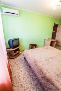 a bedroom with a bed and a tv at Apartment on Sverdlova in Tyumen