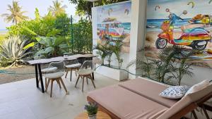 a dining room with a table and chairs and paintings at ZanziStar Beach Hotel in Mfumbwi