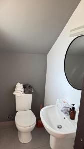a bathroom with a white toilet and a sink at ZanziStar Beach Hotel in Mfumbwi