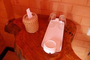 a wooden table with a toilet and two glasses on it at Changsova Hotel in Ban Chang