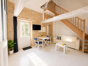 a living room with a couch and a table at Apt duplex ou plain pied tout confort plein centre ville Bayeux proche commerces, restaurants, avec terrasse privative ou jardin commun aménagé clos, parking gratuit à proximité, proche plages du débarquement in Bayeux