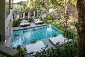 einen Blick über einen Pool mit Liegestühlen und ein Resort in der Unterkunft The Raweekanlaya Bangkok in Bangkok