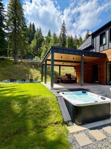 a backyard with a hot tub and a house at Cabana Nord Side in Muntele Cacovei