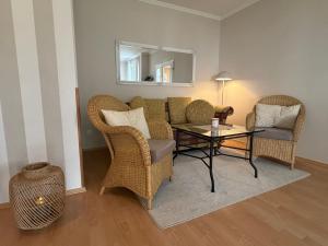 a living room with wicker chairs and a table at Villa Jugendglück in Binz