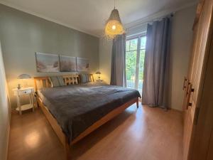 a bedroom with a large bed and a large window at Villa Jugendglück in Binz
