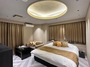 a bedroom with a large bed and a living room at ホテル侘 in Himeji