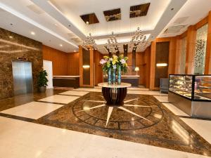 a lobby with a vase of flowers on a table at Harolds Hotel Cebu in Cebu City