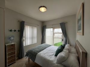 a bedroom with a bed and a window at La Palma Villa 8 in Mossel Bay